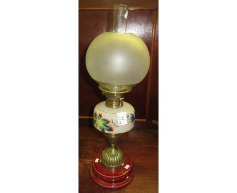 Early 20th century double oil burner with globular frosted glass shade above a painted vaseline glass reservoir on a brass fl