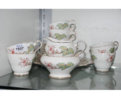 An Aynsley Teaset with pink blossom and foliage including six cups and saucers, seven tea plates, bread and butter plate and 