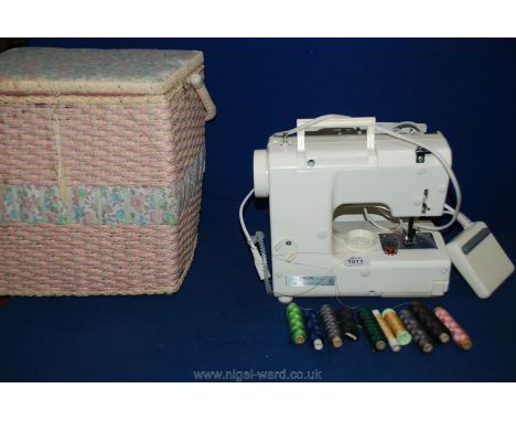 A Singer compact free-arm Sewing Machine in small basket, threads, manual, etc.