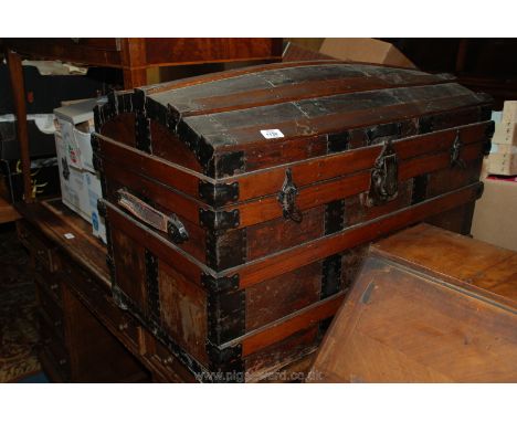 A domed wood and metal bound Trunk in good condition by Fulton.