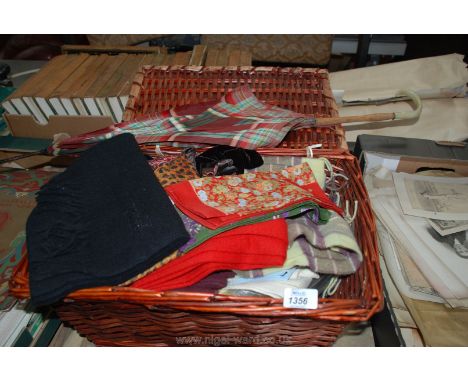 A basket of leather gloves and scarves with a vintage parasol