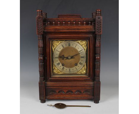 A late 19th century Arts and Crafts style oak mantel clock with eight day movement striking on two gongs, the backplate stamp