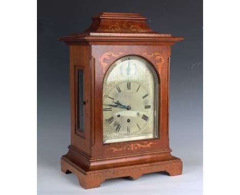 An early 20th century German mahogany bracket clock with three train movement chiming on gongs, the silvered dial with chime/