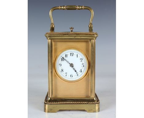 A late 19th century/early 20th century lacquered brass carriage clock with eight day movement striking hours and half hours a