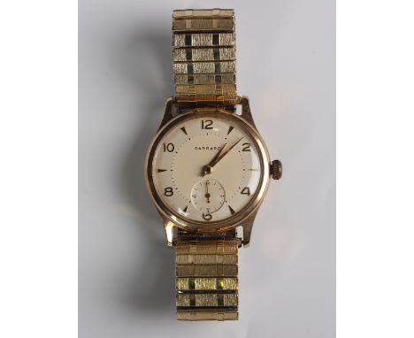 A Garrard 9ct gold circular cased gentleman's wristwatch, the signed silvered dial with gilt Arabic numerals and arrow shaped
