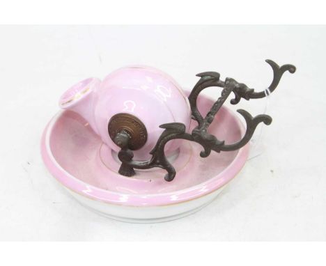 An 18th century Dutch Delft plate, decorated with a bird within a fenced garden, dia.23cm; together with a French pink lustre