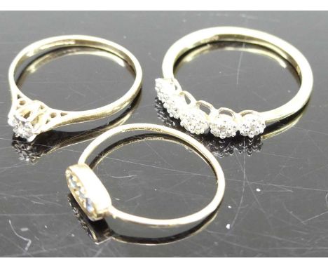 An 18ct gold diamond point set solitaire ring; together with a 9ct gold diamond point set half hoop ring; and a 9ct gold thre