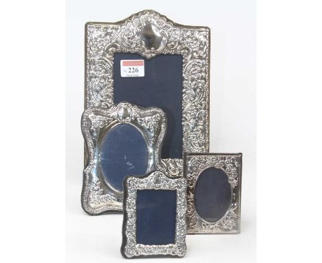 A modern repousse decorated silver easel photograph frame, in the Victorian taste, Sheffield, 14 x 9cm; together with three f