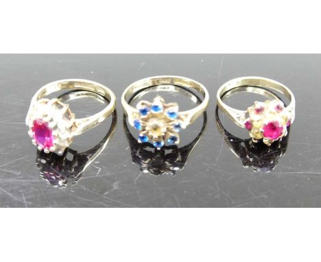 A 9ct gold, blue and white paste set cluster ring, size N; together with two 9ct gold ruby and white paste set dress rings, g