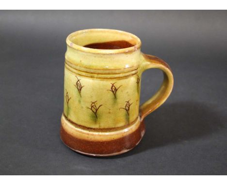 MICHAEL CARDEW - WINCHCOMBE TANKARD an earthenware tankard with a brown and green slip, with decorative motifs around the cen