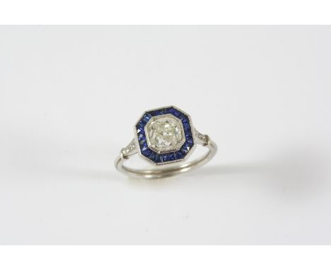 A SAPPHIRE AND DIAMOND CLUSTER RING the cushion-shaped diamond weighs approximately 1.35 carats and is set within a surround 