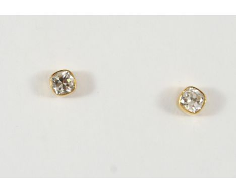 A PAIR OF DIAMOND STUD EARRINGS each earring set with a cushion-shaped diamond in gold collet mount.