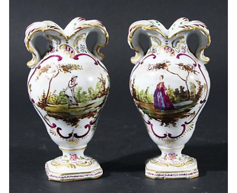 PAIR OF HOCHST VASES, of inverted pear form with foliate rim scrolling into handles, painted with scenes of ladies in gardens