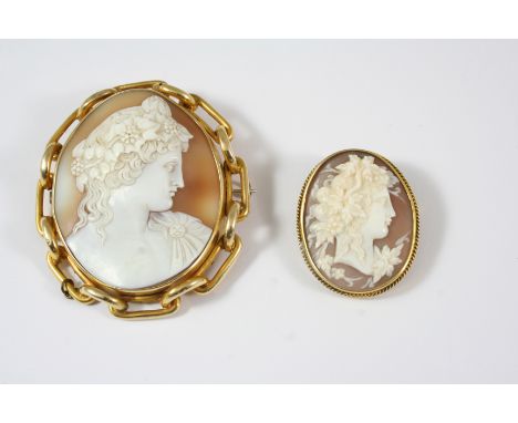 AN OVAL CARVED SHELL CAMEO BROOCH depicting a Bacchic youth known as Antinous, wearing a wreath and a cloak, in a gold chain 