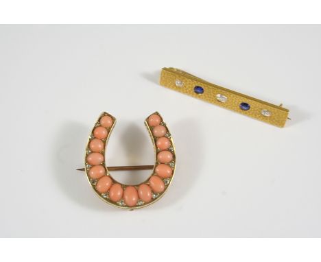 A LATE VICTORIAN CORAL AND DIAMOND HORSESHOE BROOCH the gold mount with graduated oval-shaped coral cabochons with rose-cut d