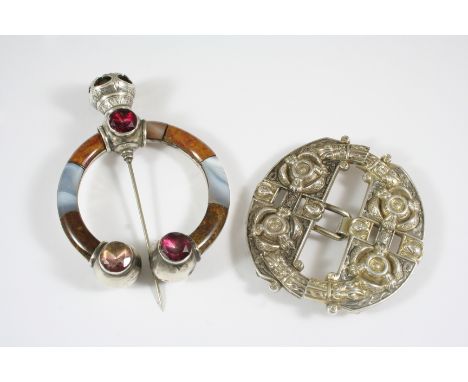 A VICTORIAN SCOTTISH AGATE AND SILVER CLOAK BROOCH formed with assorted sections of agate, with a swing pin, 9cm. long, and a