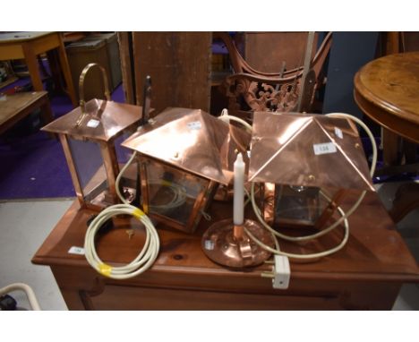 Three copper wall lights, lantern style, and a pair of copper candlesticks