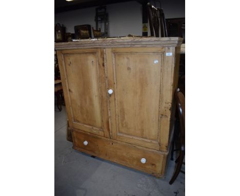 An antique stripped yellow pine cloak cupboard with under drawer and ceramic handles