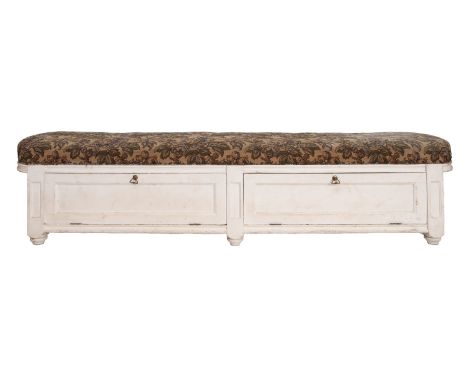 A cream painted ottoman window seat with upholstered tapestry top and two hinged flaps to the compartment below, 160cm long x