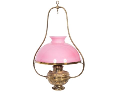 A late Victorian/Edwardian brass hanging oil lantern, with pink opaque glass shade, shaped uprights and circular oil font wit
