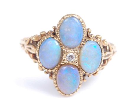 An 18ct yellow gold opal doublet quatrefoil cluster ring, with a centre round brilliant cut diamond, all in millegrain bezel 