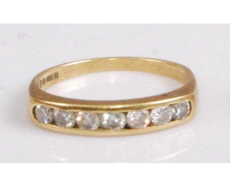 An 18ct gold diamond half eternity ring, arranged as seven channel set brilliants, total diamond weight estimated as approx 0