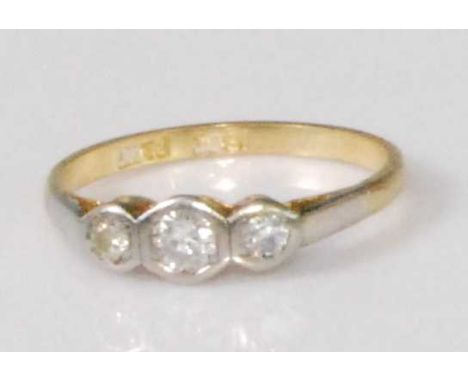 An 18ct gold and platinum diamond three stone ring, the round cut diamonds being illusion set, the centre stone weighing appr