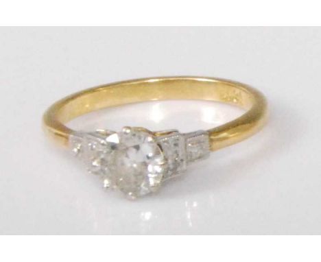 An 18ct gold diamond solitaire ring, the claw set round cut diamond weighing approx 0.75 carat, the shoulders each pavé set w