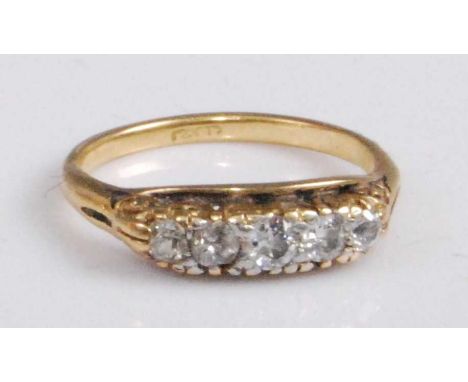 An 18ct gold diamond five-stone ring, the graduated old cut diamonds in a carved line setting, the centre stone weighing appr