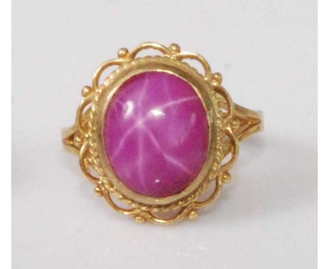 A 9ct gold 'synthetic' pink star sapphire set dress ring, the cabochon stone measuring approx 12 x 9 x 4mm, 4.8g, size M