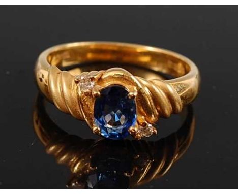 An 18ct yellow gold, sapphire and diamond dress ring, comprising an oval faceted sapphire with a round brilliant cut diamond 