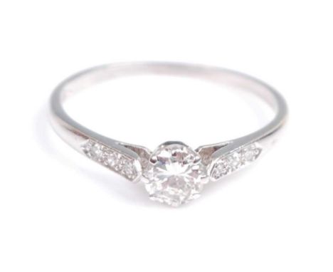 A white metal diamond solitaire ring, comprising a round brilliant cut diamond in an eight claw setting, with three single cu