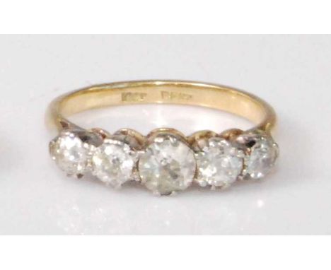 An 18ct gold and platinum diamond five stone ring, the graduated claw-set old cut diamonds in a line setting, the centre ston