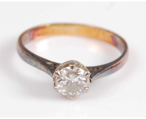 A yellow and white metal single stone diamond ring, featuring a round brilliant cut diamond in a six-claw pierced heart colle