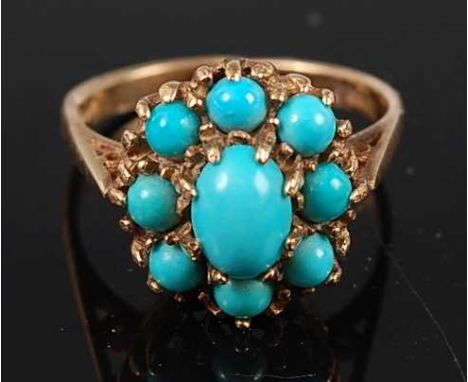 A 9ct yellow gold turquoise set cluster ring, featuring a centre oval and eight round cabochon cut turquoise in claw settings