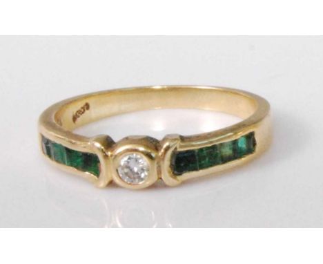 An 18ct gold, emerald and diamond half hoop ring, arranged as an illusion set brilliant cut diamond weighing approx 0.08 cara