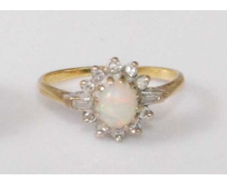 An 18ct gold, opal and diamond dress ring, the centre cabochon opal flanked to either side by twin baguette diamonds, within 