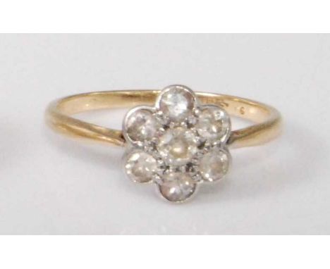 A circa 1930 yellow metal diamond set flowerhead cluster ring, arranged as seven pavé set old brilliants, each weighing appro