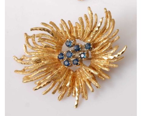 A yellow metal sapphire abstract spray brooch, comprising a centre section of eight round sapphires within a radiating spray 