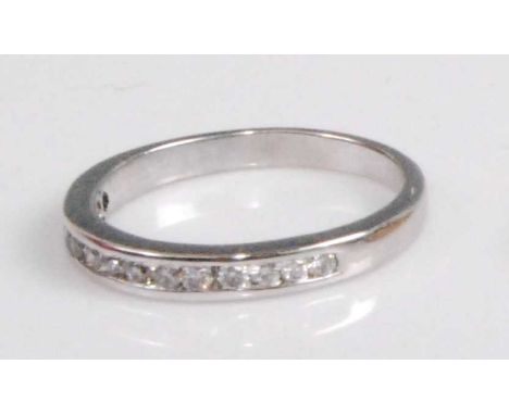 A contemporary 18ct white gold diamond half eternity ring, arranged as thirteen small channel set brilliants, total diamond w