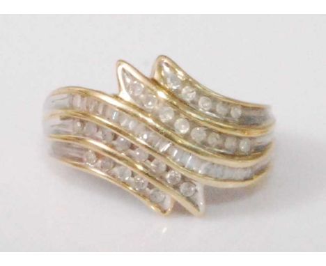 A contemporary 9ct gold diamond set dress ring, arranged as five tiered rows of channel set baguettes and brilliants, total d