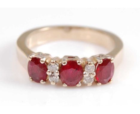 A yellow metal, ruby and diamond seven stone half hoop eternity ring, comprising three oval rubies interspersed with four rou