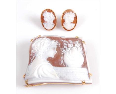 A yellow metal carved shell cameo brooch and earring suite, the trapeze shaped brooch measuring 50 x 35mm and depicting a cla