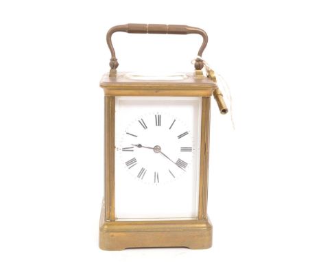An early 20th century brass carriage mantel clock. Movement to verso, white face with ebonised chapter ring. Key is present. 