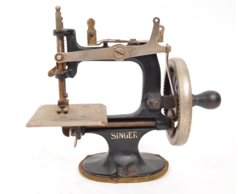 Singer - An early 20th century Singer model 20 miniature sewing machine. The machine having a black metal body, stamped with 