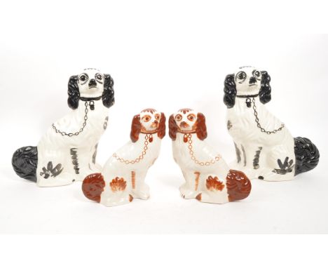 Two pairs of 20th Century ceramic hand painted Staffordshire spaniel dogs. The larger examples black and white whilst the sma