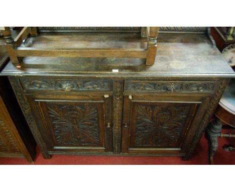 A circa 1900 heavily relief carved oak ledgeback double door sideboard, having twin Green Man mask carved handled frieze draw