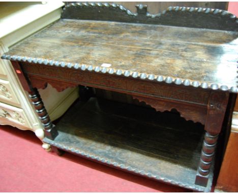 A joined and chip carved oak ledgeback two-tier side table, raised on bobbin turned supports, with single end drawer, width 9