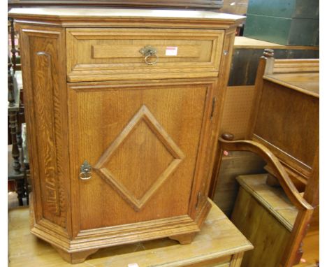 A contemporary oak credence shaped single door side cupboard, having single upper drawer, w.71cm; together with an oak framed