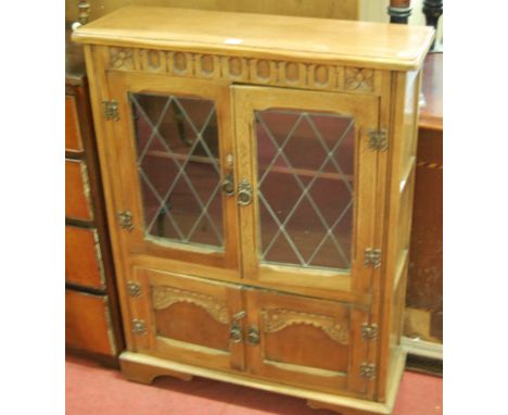 A contemporary mid-oak four door side cabinet, having lead glazed upper doors, Dimensions; h.106cm, w.78cm, d.26cm.